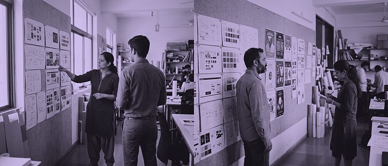 Designers reviewing printed work on a wall