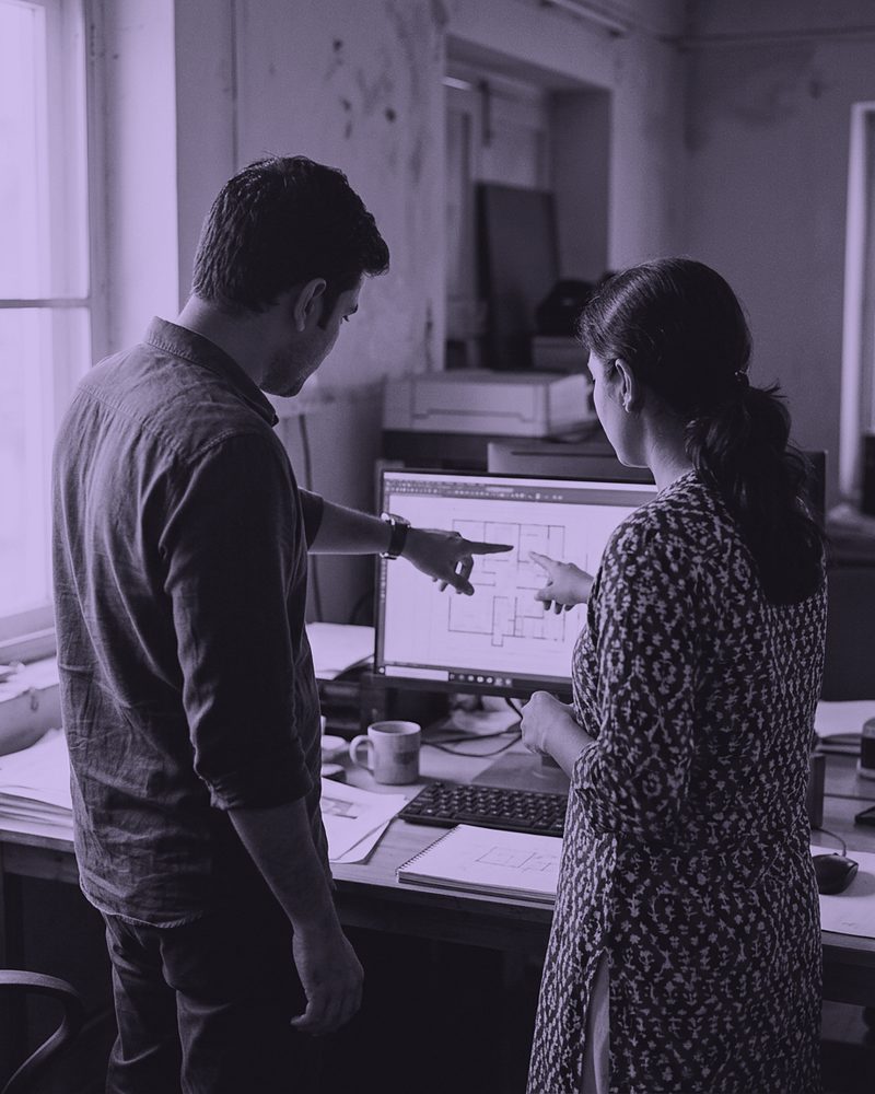 Two colleagues reviewing work on a screen